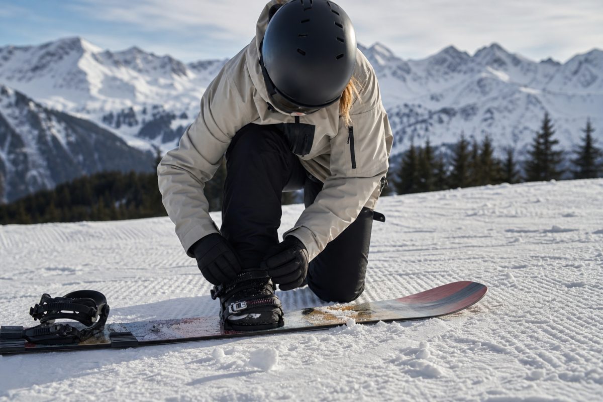 Snowboard kabát mozgás közben kötéscsatolásnál havas pályán