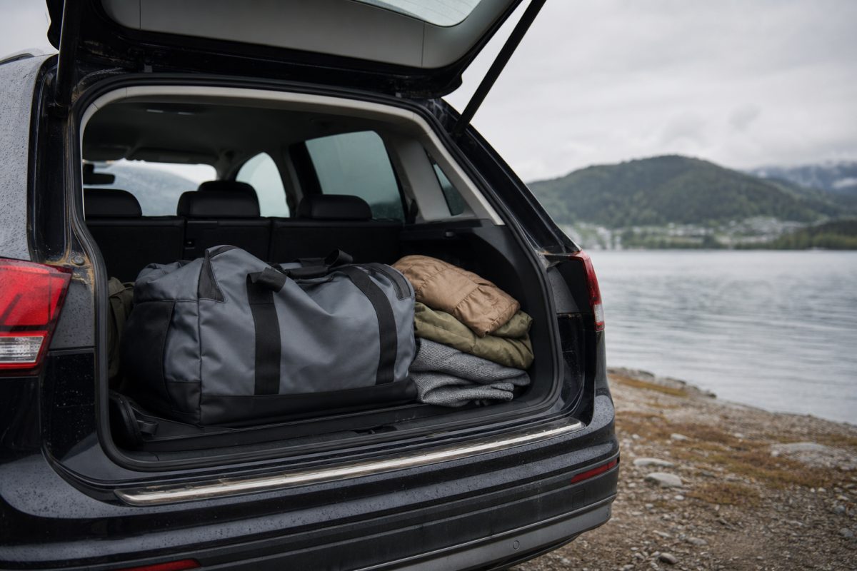 Duffel bag autó csomagtartójában utazáshoz pakolt ruhákkal